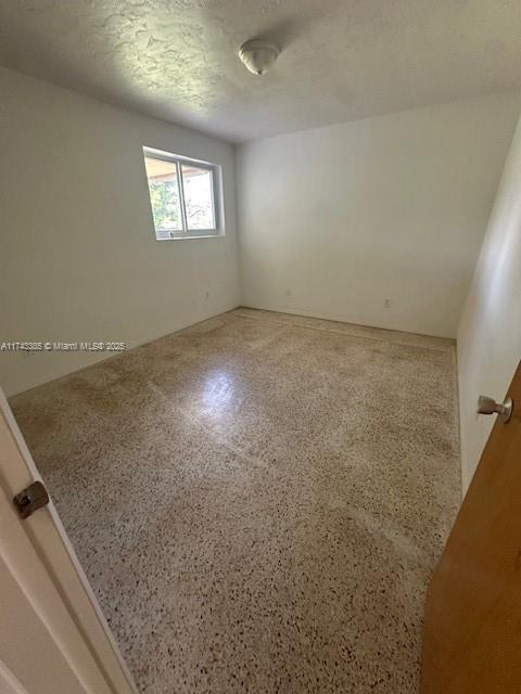 unfurnished room featuring a textured ceiling