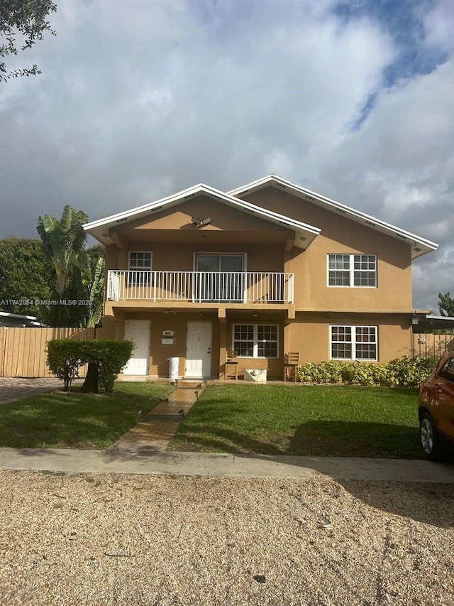 view of front of property featuring a front yard and a balcony