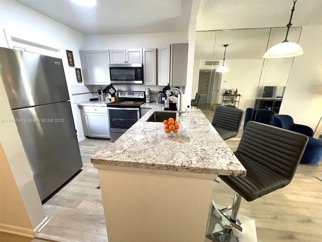 5102 NW 36th St Unit 611, Lauderdale Lakes, FL 33319 - kitchen with appliances with stainless steel finishes, a sink, light stone countertops, and light wood finished floors