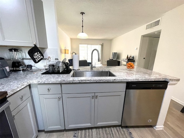 5102 NW 36th St Unit 611, Lauderdale Lakes, FL 33319 - kitchen featuring a sink, dishwasher, a peninsula, light wood-style flooring, and gray cabinetry