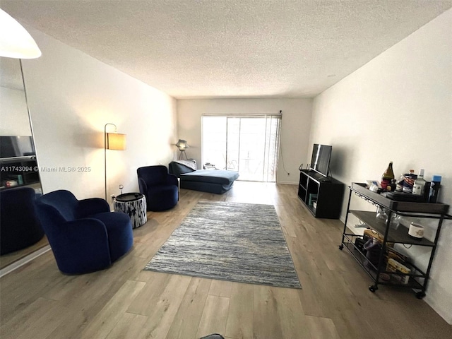 5102 NW 36th St Unit 611, Lauderdale Lakes, FL 33319 - living room featuring wood finished floors and a textured ceiling