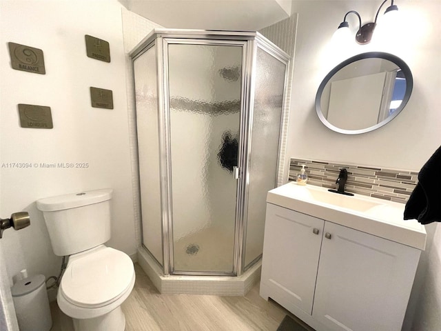 5102 NW 36th St Unit 611, Lauderdale Lakes, FL 33319 - bathroom featuring vanity, a stall shower, toilet, tasteful backsplash, and wood finished floors