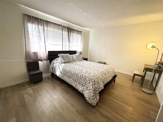 5102 NW 36th St Unit 611, Lauderdale Lakes, FL 33319 - bedroom with hardwood / wood-style flooring, a textured ceiling, and baseboards