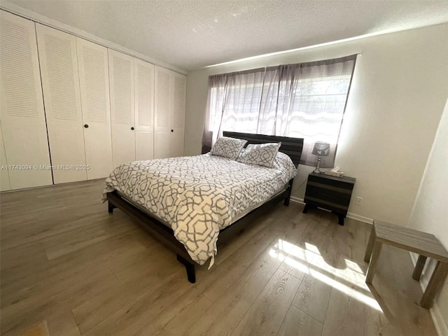 5102 NW 36th St Unit 611, Lauderdale Lakes, FL 33319 - bedroom featuring wood finished floors, a textured ceiling, a closet, and baseboards