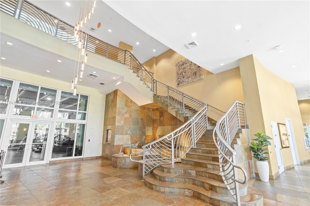 stairs featuring french doors and a towering ceiling