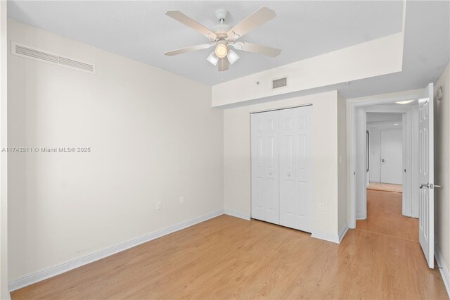 unfurnished bedroom featuring a closet, ceiling fan, and light hardwood / wood-style flooring