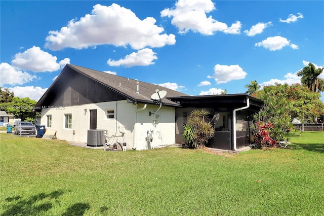 back of property featuring central AC and a yard