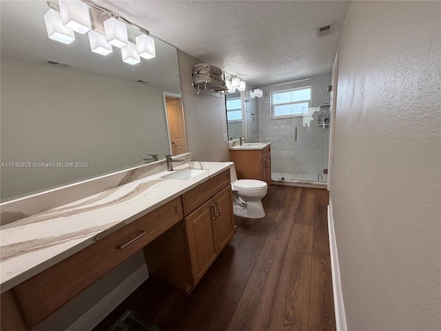 bathroom featuring vanity, hardwood / wood-style floors, an enclosed shower, and toilet