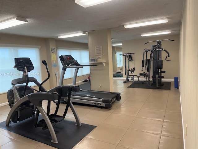 workout area featuring light tile patterned floors and a textured ceiling