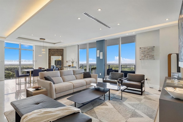 living room featuring expansive windows, plenty of natural light, and a tray ceiling