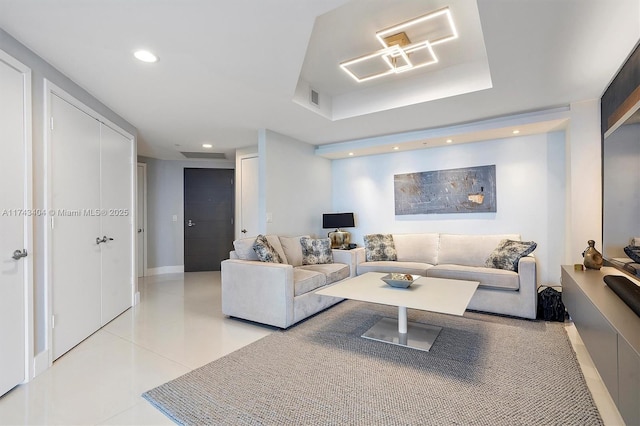 living room with light tile patterned flooring and a tray ceiling