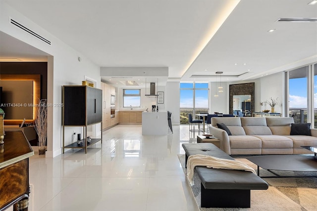 living room with a healthy amount of sunlight, sink, and a wall of windows