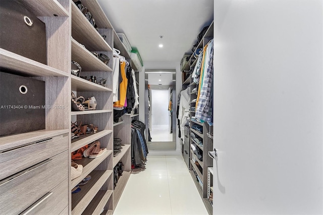 walk in closet with light tile patterned floors