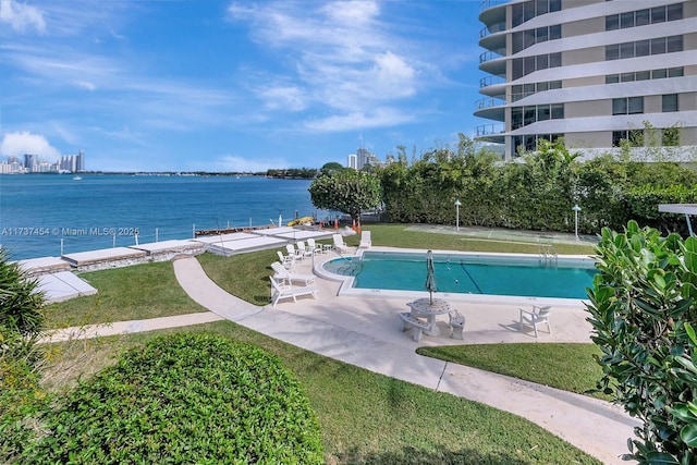 view of swimming pool with a water view, a yard, and a patio