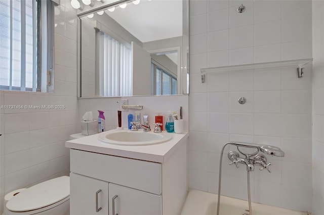 bathroom featuring tile walls, vanity, and toilet