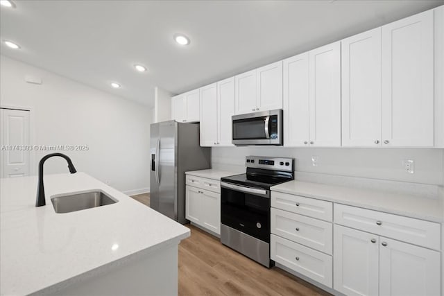 kitchen with white cabinetry, appliances with stainless steel finishes, sink, and light wood-type flooring