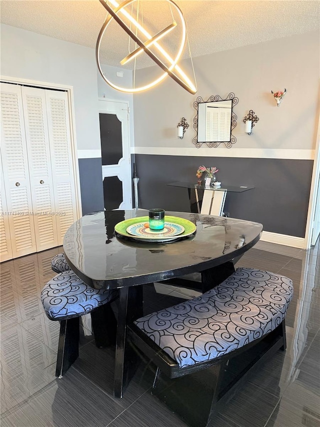 dining space with a chandelier and a textured ceiling