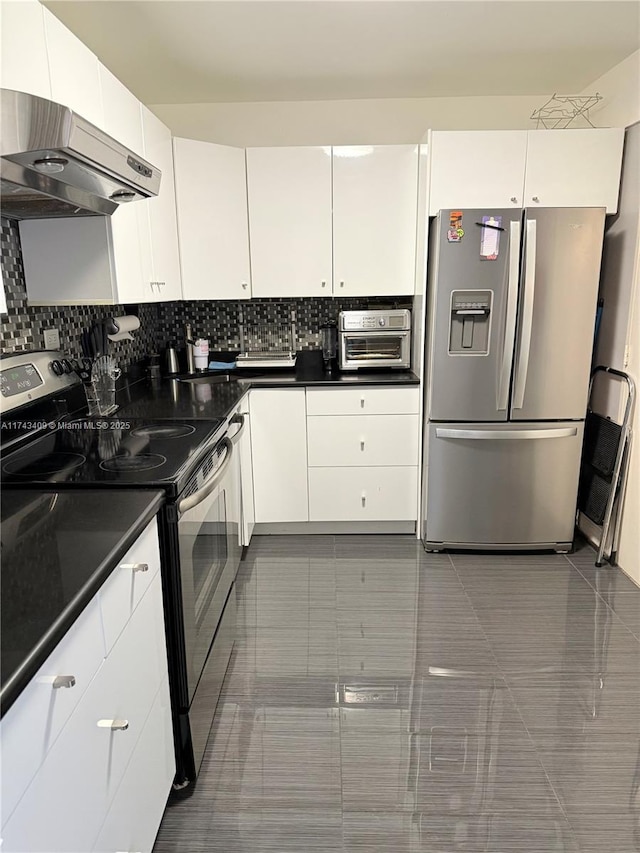 kitchen with decorative backsplash, ventilation hood, white cabinets, and appliances with stainless steel finishes