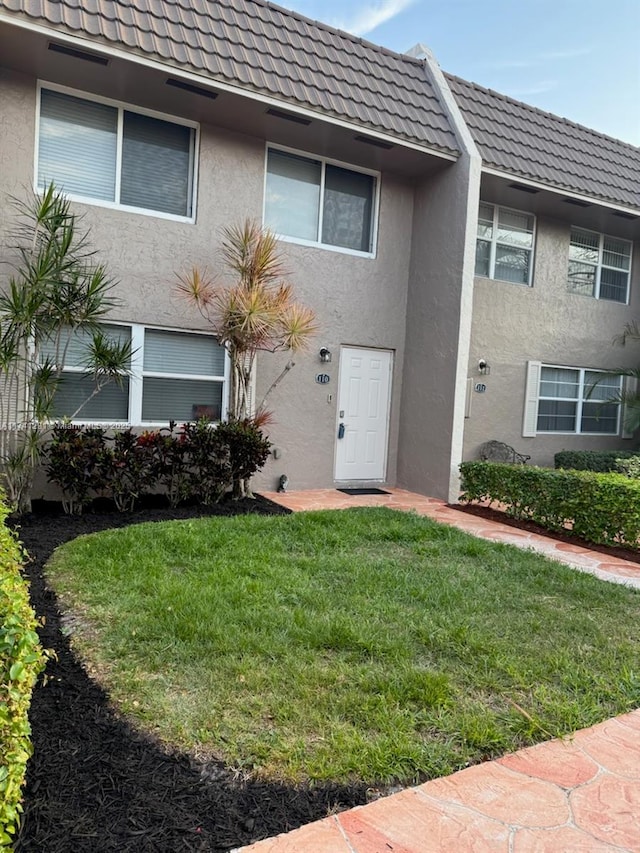 9050 NW 28th St Unit 110, Coral Springs, FL 33065 - townhome / multi-family property featuring a tiled roof, a front lawn, and stucco siding