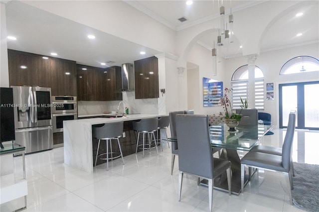 dining area featuring french doors, ornamental molding, and sink