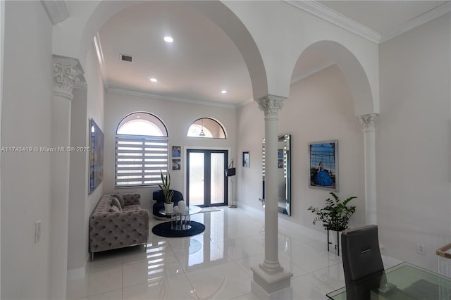 foyer with ornate columns, crown molding, and french doors