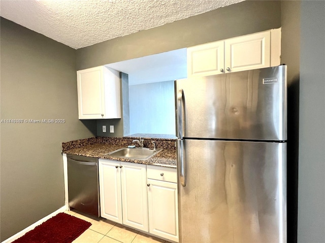 kitchen with white cabinetry, dishwashing machine, sink, and stainless steel fridge