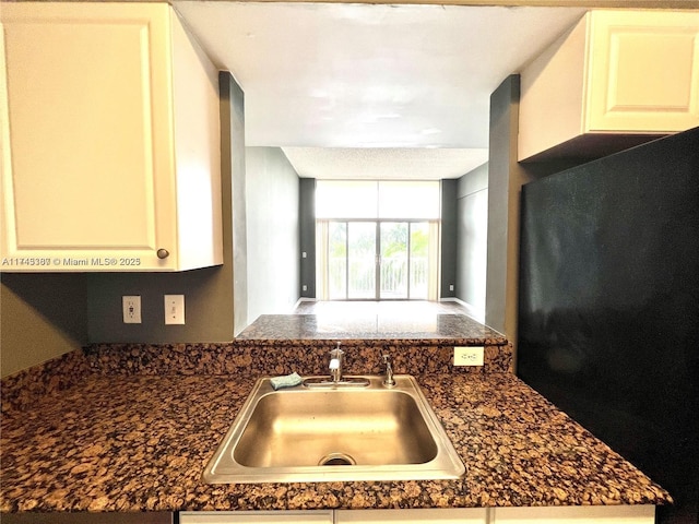 kitchen featuring white cabinetry, sink, and dark stone countertops