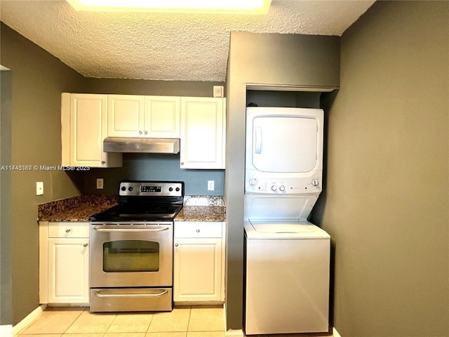 kitchen featuring stainless steel electric range oven, white cabinetry, dark stone countertops, stacked washer and clothes dryer, and a textured ceiling