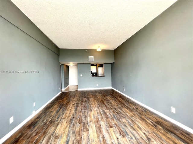 unfurnished living room with dark hardwood / wood-style flooring and a textured ceiling