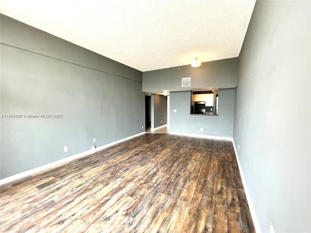 unfurnished living room with wood-type flooring and a textured ceiling