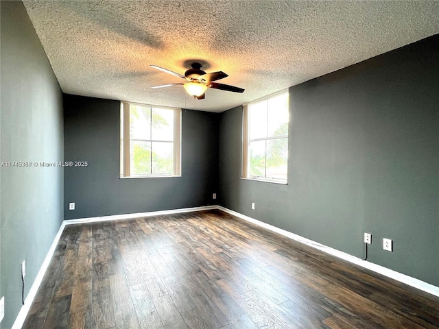 spare room with ceiling fan, plenty of natural light, a textured ceiling, and dark hardwood / wood-style flooring