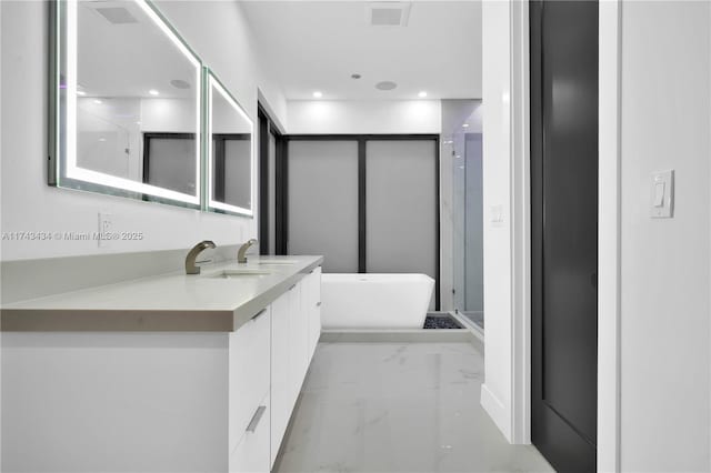 bathroom with vanity and shower with separate bathtub