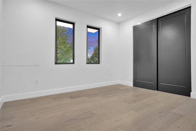 unfurnished bedroom with a closet and light hardwood / wood-style flooring