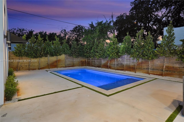 pool at dusk with a patio