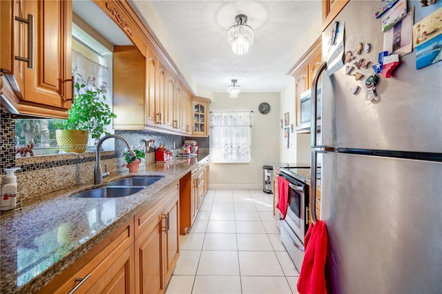 kitchen with sink, backsplash, stainless steel appliances, and stone counters