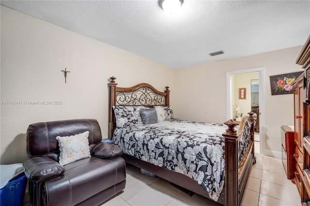 bedroom with light tile patterned floors and a textured ceiling