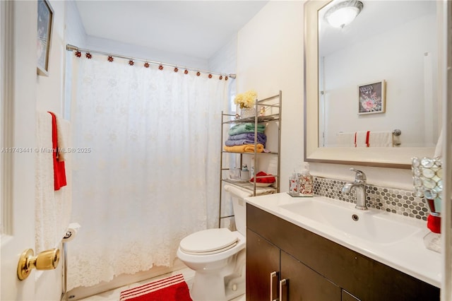 bathroom featuring vanity, decorative backsplash, and toilet