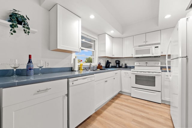 kitchen with white cabinetry and white appliances