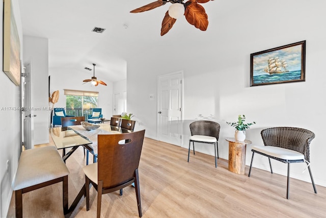 dining space with ceiling fan, lofted ceiling, and light hardwood / wood-style floors