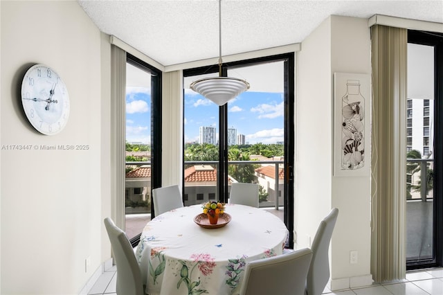 dining room with expansive windows, a textured ceiling, and light tile patterned floors