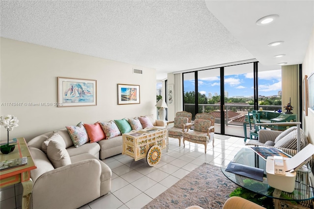 living room featuring floor to ceiling windows, a textured ceiling, and light tile patterned floors