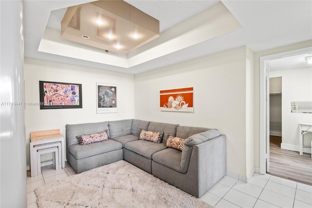 tiled living room featuring a tray ceiling