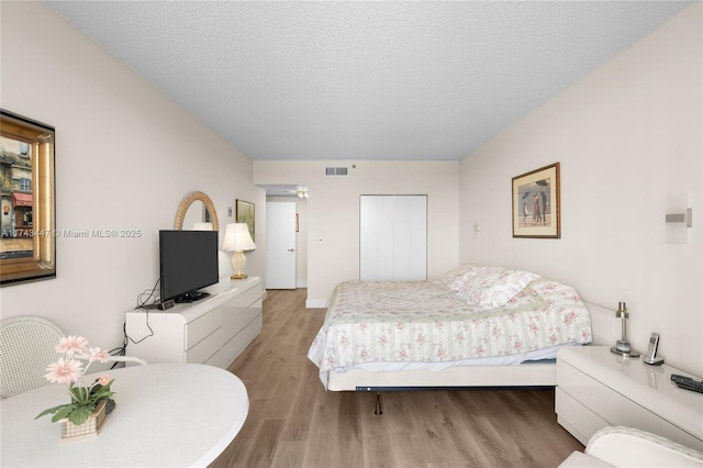 20281 E Country Club Dr Unit 403, Aventura, FL 33180 - bedroom with light wood-style floors, a textured ceiling, and baseboards