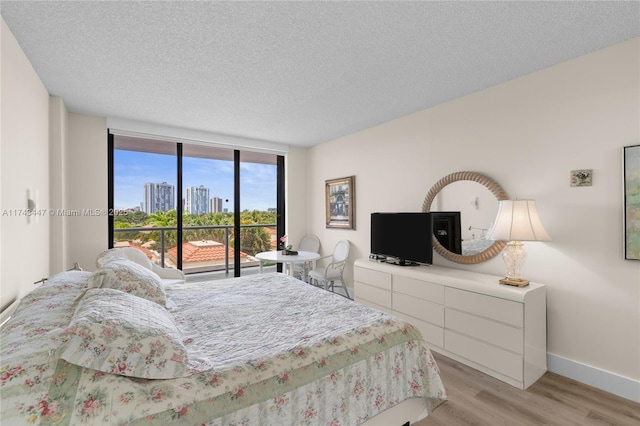 20281 E Country Club Dr Unit 403, Aventura, FL 33180 - bedroom with light wood-style flooring, access to outside, a textured ceiling, and baseboards