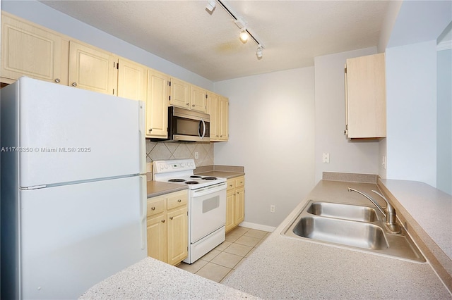 kitchen with tasteful backsplash, sink, light tile patterned floors, and white appliances