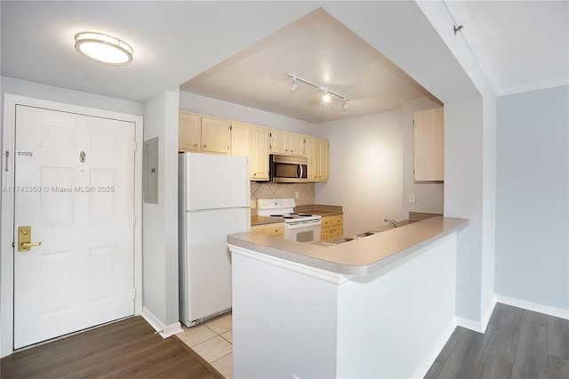 kitchen featuring light wood-type flooring, white appliances, sink, and backsplash