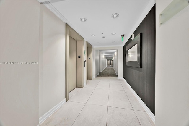 corridor featuring ornamental molding, elevator, and light tile patterned floors