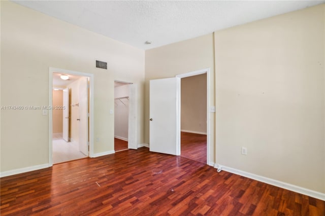 unfurnished room featuring dark hardwood / wood-style floors and a textured ceiling