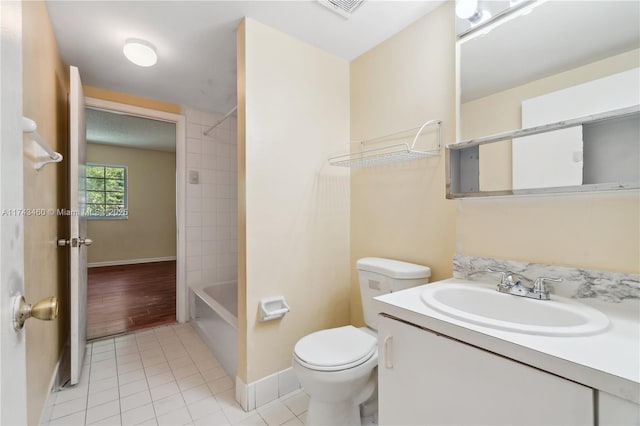 full bathroom featuring tiled shower / bath, vanity, toilet, and tile patterned flooring