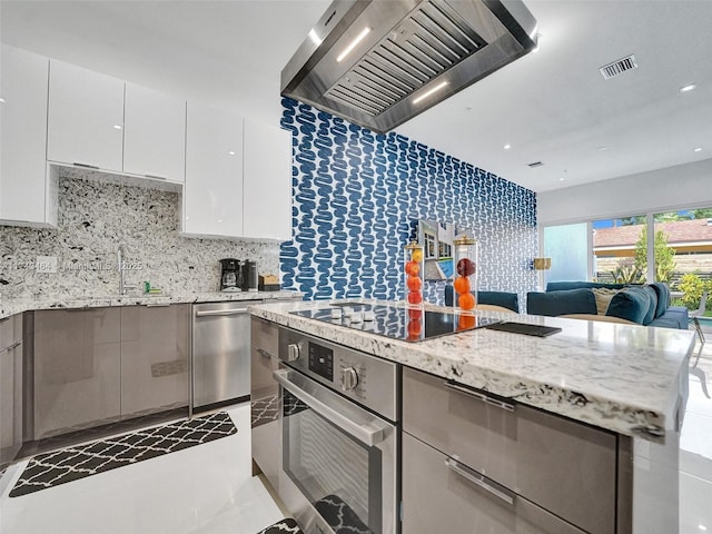 kitchen featuring premium range hood, white cabinetry, oven, black electric stovetop, and light stone countertops